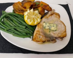 A plate with pork chops and green beans.