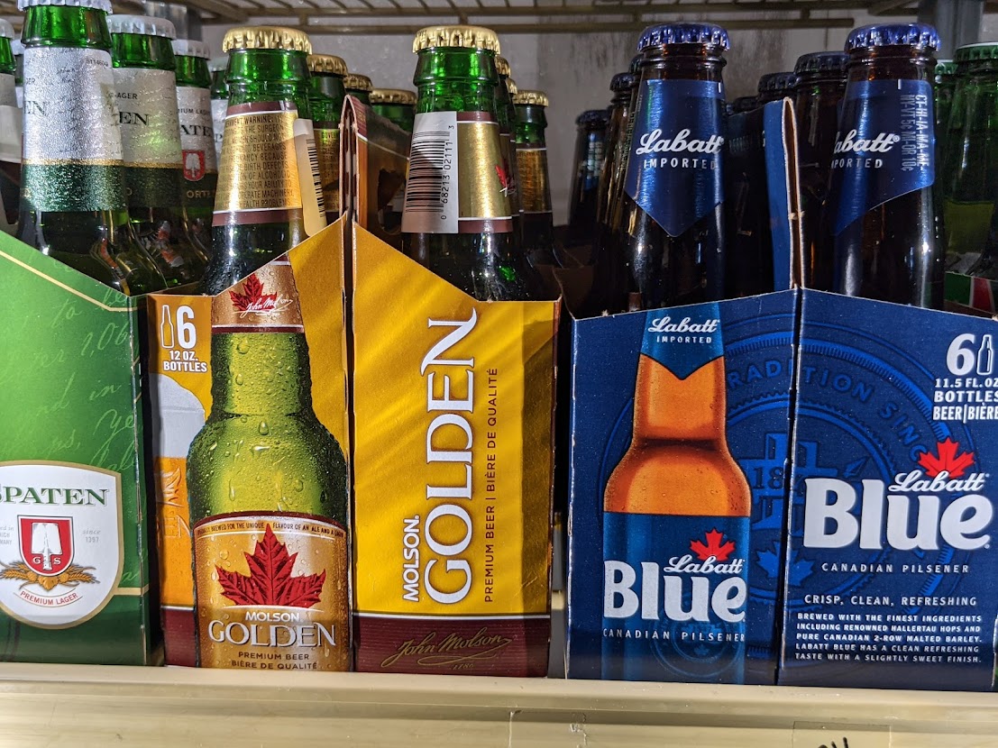 A row of beer bottles on a shelf.